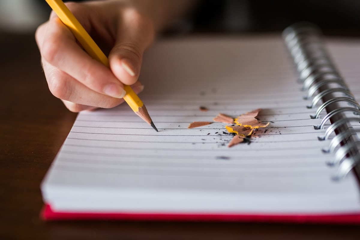 A hand poised with a pencil over a blank notebook: the forward-looking planning this question rewards
