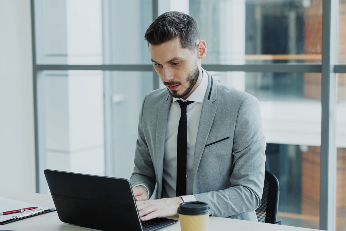A young professional preparing at a laptop in an office before a first job interview