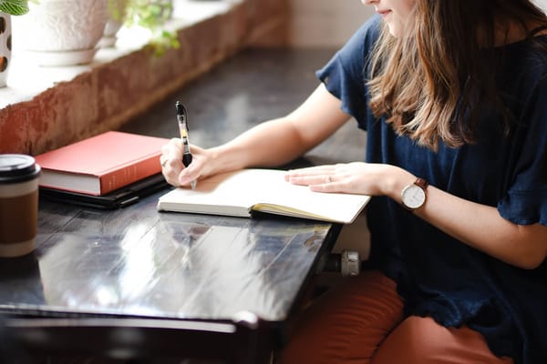 A person reflecting with a journal: the inward work that powers an authentic "what motivates you" answer