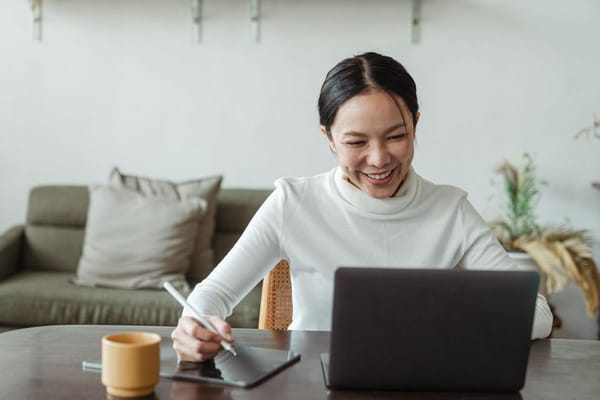 Candidate practicing interview answers on a laptop video call while preparing at a home office desk
